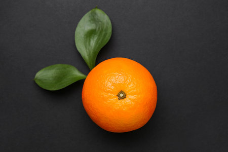 Fresh ripe orange and leaves on black backgroundの写真素材