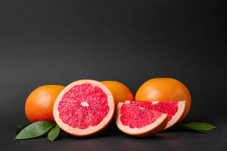 Fresh ripe grapefruits with leaves on black backgroundの写真素材