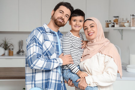 Happy Muslim family hugging in kitchenの写真素材