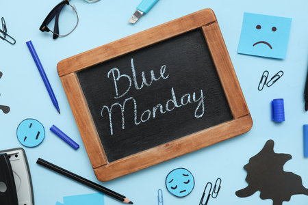 Chalkboard with text BLUE MONDAY, sad faces and office stationeryの写真素材