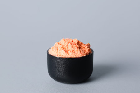 Bowl of orange powder pigment on light backgroundの写真素材