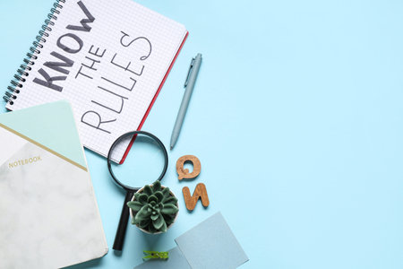 Notebook with text KNOW THE RULES and stationery on blue background