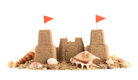 Castle made of sand with flags and different seashells on white backgroundの写真素材