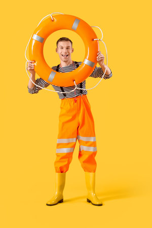 Male sailor with rescue ring on yellow background