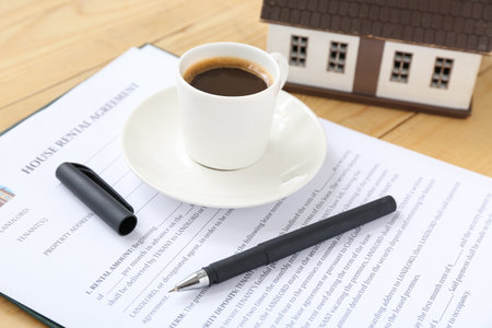 Blank house rental agreement with cup of coffee on wooden background, closeupの写真素材