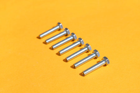 Row of tap bolts on orange background
