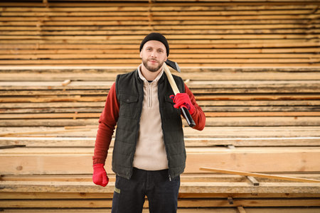 Male carpenter with ax at sawmill
