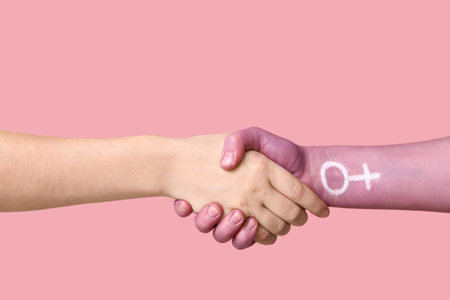 Women shaking hands on pink background. Feminism conceptの写真素材