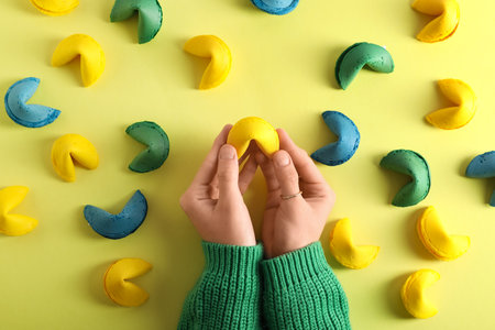 Female hands with different fortune cookies on yellow backgroundの写真素材