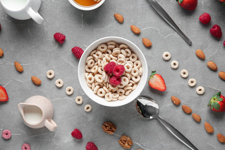 Bowl with healthy cereal rings, nuts and berries on gray grunge backgroundの写真素材