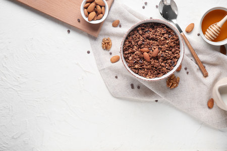 Bowl with chocolate cornflakes and nuts on white backgroundの写真素材