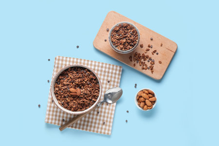 Bowls with tasty chocolate granola on blue backgroundの写真素材