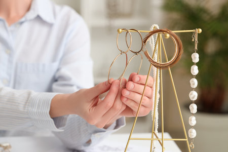 Young female jewelry designer with adornments at table in workshop, closeupの写真素材
