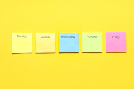 Different blank sticky notes with names of weekdays on yellow background