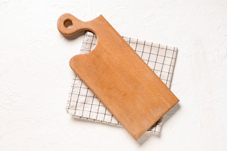 Empty cutting board with napkin on white grunge table, top viewの写真素材