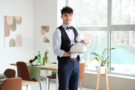 Male waiter with cloche in restaurant