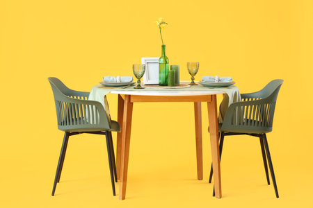 Served restaurant table with flower on yellow backgroundの写真素材