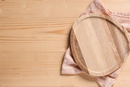 Empty cutting board with napkin on wooden table, top viewの写真素材