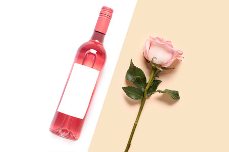 Bottle of pink wine and beautiful rose on colorful backgroundの写真素材