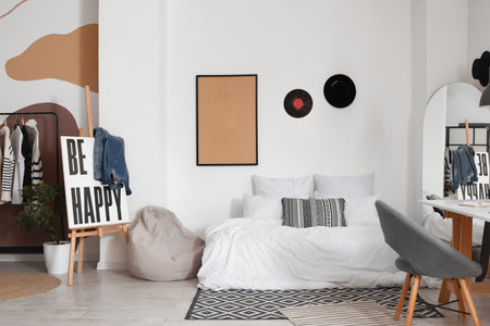 Interior of teenager's room with bed, mirror and easelの写真素材