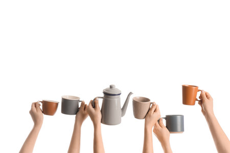 Female hands with teapot and mugs on white backgroundの写真素材