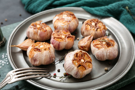 Plate with baked garlic, peppercorns and thyme, closeupの写真素材