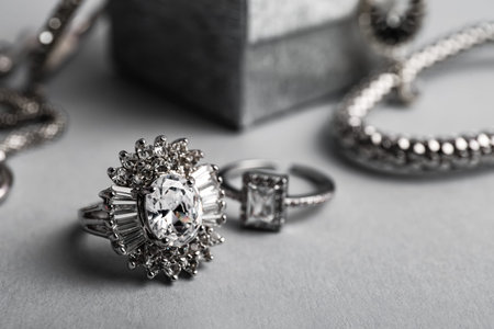 Beautiful silver rings and bracelet on gray background, closeupの写真素材