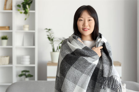 Young Asian woman with soft plaid at homeの写真素材