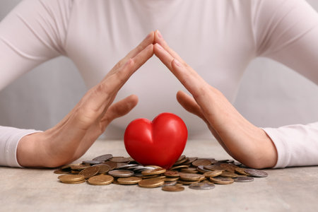 Woman with red heart and coins on tableの写真素材