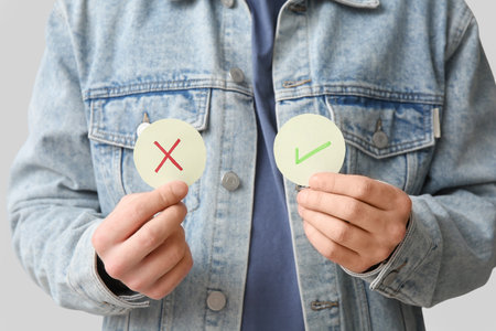 Man with rating marks on light background, closeup. Survey conceptの写真素材