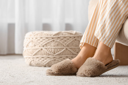 Young woman in soft comfortable slippers relaxing at homeの写真素材