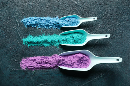 Scoops of powder pigments on dark backgroundの写真素材