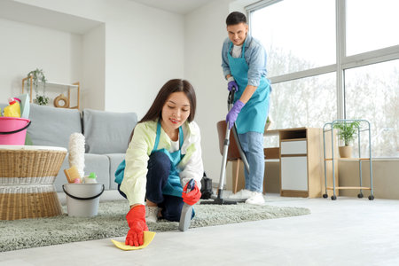 Cute young couple cleaning living room together