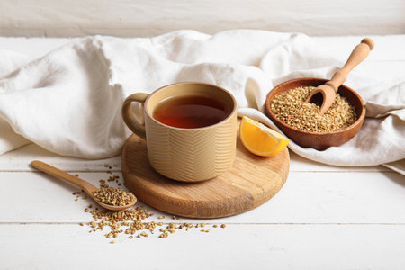 Cup of hot buckwheat tea with lemon on white wooden backgroundの写真素材