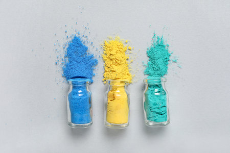 Jars of powder pigments on light background