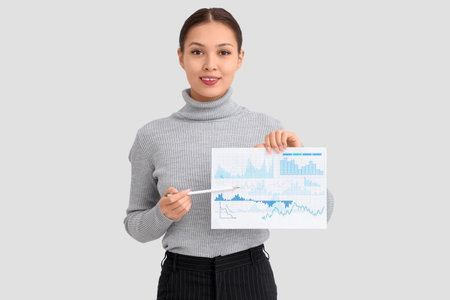 Young Asian businesswoman with charts on white backgroundの写真素材
