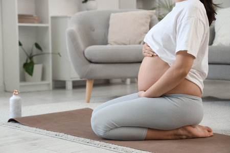 Sporty young pregnant woman at homeの写真素材