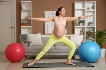 Young pregnant woman doing yoga at homeの写真素材