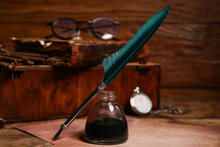 Old paper sheets with nib pen, inkwell and pocket watch on wooden backgroundの写真素材