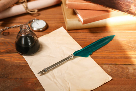 Paper sheet with nib pen, inkwell and pocket watch on wooden background