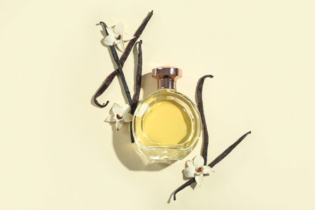 Bottle of perfume, vanilla sticks and flowers on color backgroundの写真素材