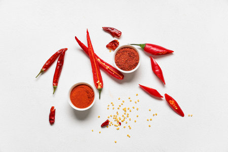Bowls with red chili powder and flakes on white backgroundの写真素材
