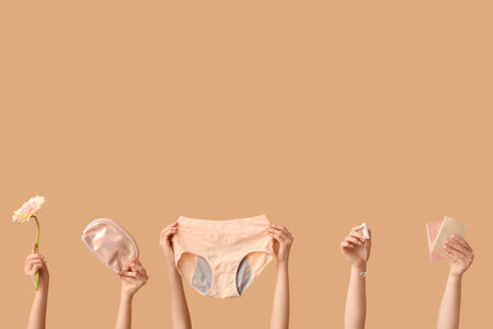 Many female hands with period panties, menstrual pads and tampon on beige backgroundの写真素材