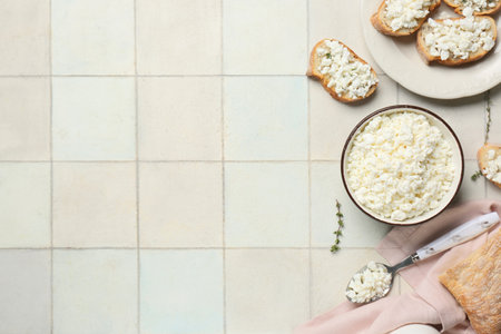 Plate of bread slices with fresh cottage cheese and thyme on white tile backgroundの写真素材