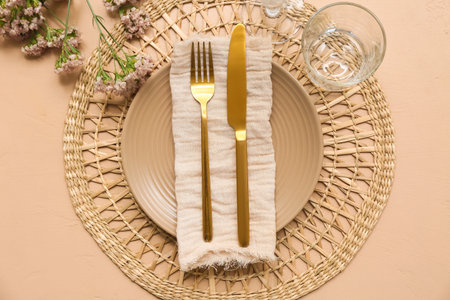 Beautiful table setting with flowers on beige backgroundの写真素材