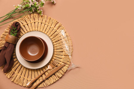 Beautiful table setting with flowers and leaves on brown backgroundの写真素材