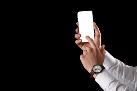 Man using blank mobile phone on black backgroundの写真素材