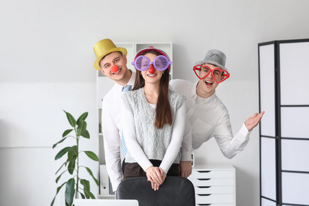 Young colleagues with funny disguise in office. April Fools' Day celebrationの写真素材