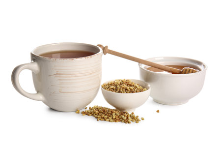 Cup of hot buckwheat tea and bowl with honey on white backgroundの写真素材