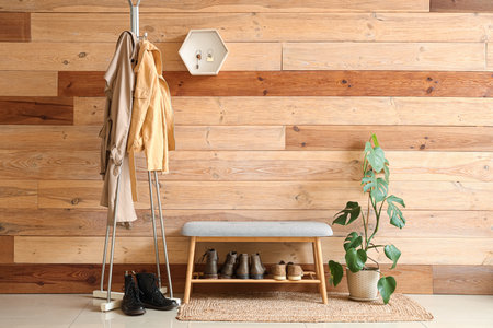 Interior of stylish hall with clothes rack, gray bench and key holder on wooden wallの写真素材